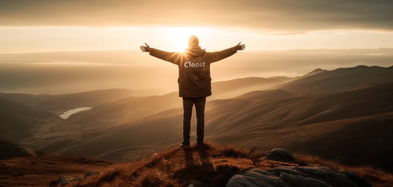 Hombre en una montaña despalda con el logo de Cloost